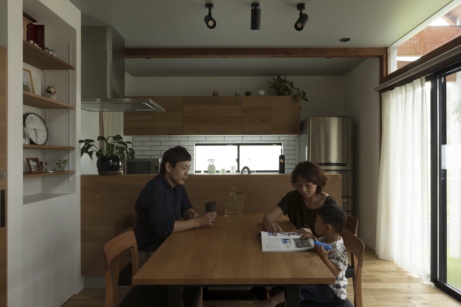 father taking tea and mother teaching her kid 