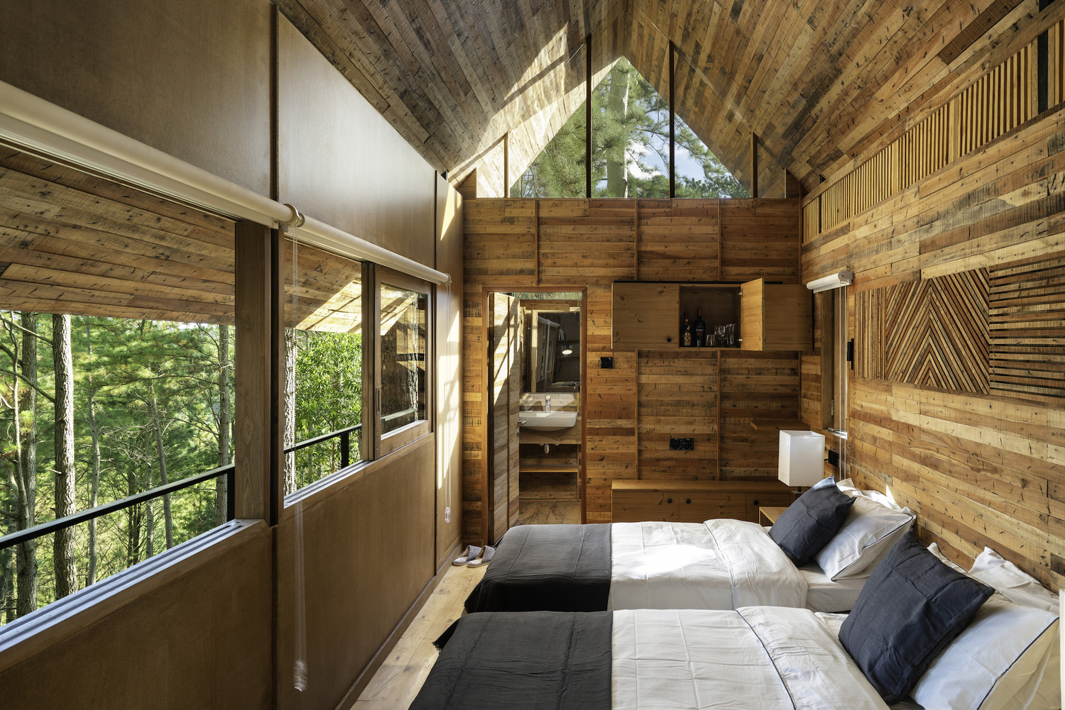 bedroom with opened windows toward the forest 