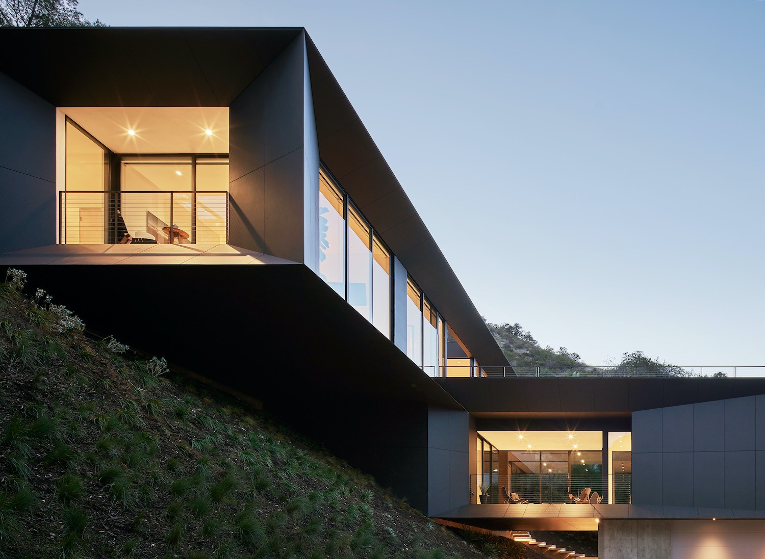 house with black metallic facade build on a hill 