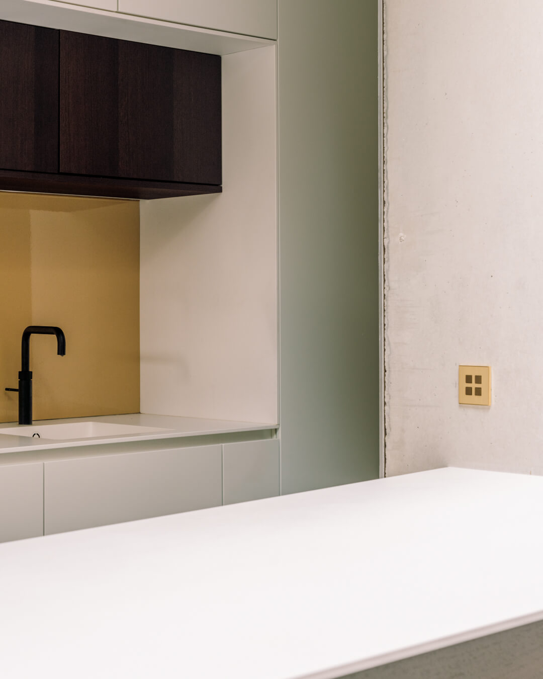 Rekonstrukce řadového domu: elegantní přístavba s ukrytou kuchyní a surové materiály